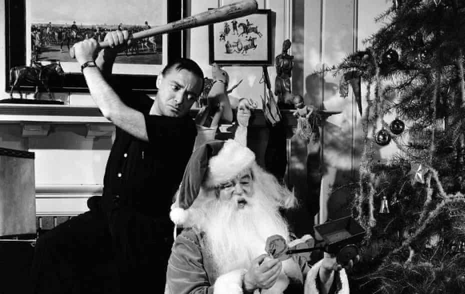 Black and white photograph of Peter Lorre holding a baseball bat over Sydney Greenstreet dressed as Father Christmas