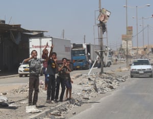 Kids cheer on the pa ssing cars in new Mosul on 11 July.