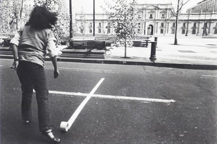 Person standing in front of a cross opposite La Moneda Palace, Santiago de Chile, 1979.
