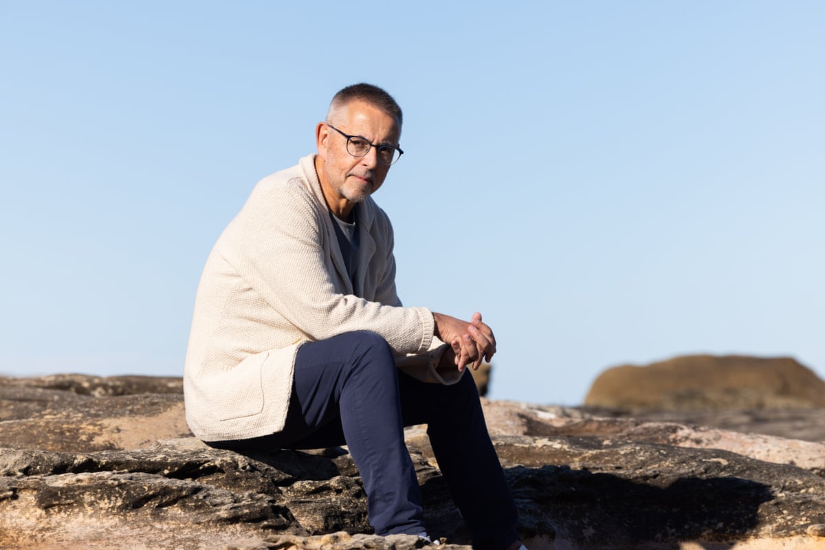 Norman Swan sits on rocks at Clovelly