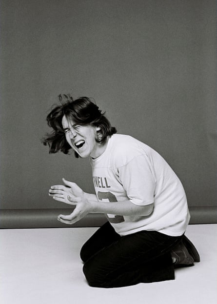 Crowe kneels on the ground, eyes closed tightly, mid-clap in Los Angeles in 1978.