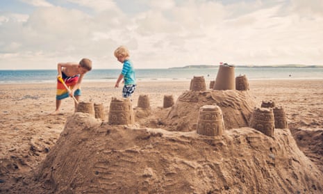 Two little boys building sandcastle on beach
