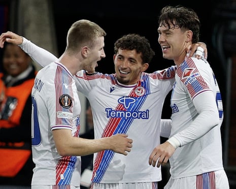 Crystal Palace players Pino, Wharton and Strand Larsen embrace, celebrating the first goal