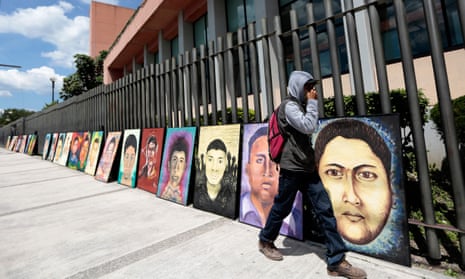 A person walks past portraits of some of the 43 missing students in September 2015. 