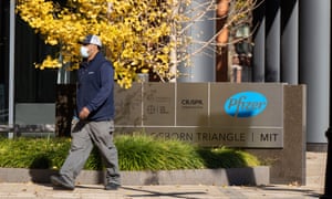 A man walks past a sign outside of a facility occupied by Pfizer laboratory on Port Street in Cambridge, 10 November 2020.