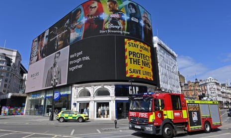 A government notice advising people to ‘stay home, protect the NHS, save lives’ is displayed on a large screen at Piccadilly Circus in central London