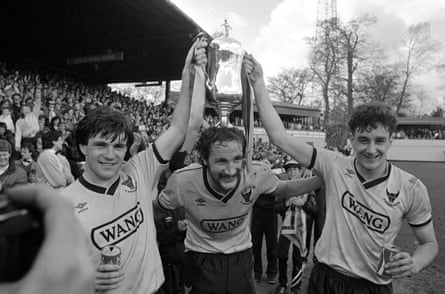 Ray Houghton, Billy Hamilton et John Aldridge montrent à leur public la Milk Cup, qu'Oxford United avait remportée en avril, après que la victoire 3-0 contre Arsenal leur ait permis de rester debout.