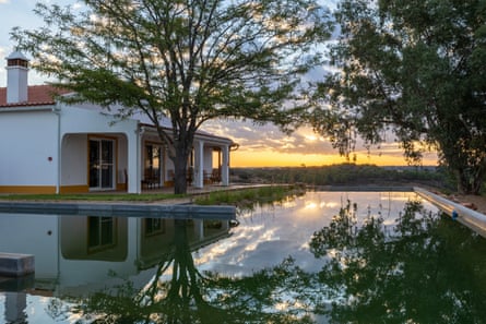 A whitewashed house surrounded by a pool