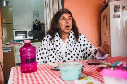Solange Rodrigues Correa sitting at a kitchen table in a white dressing gown with black polka dots.