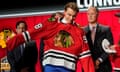 Connor Bedard puts on a Chicago Blackhawks jersey after being picked by the team during the first round of the NHL draft on Wednesday in Nashville.