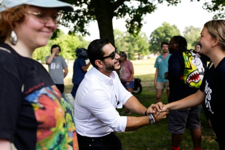 a man shakes a woman’s hand outside