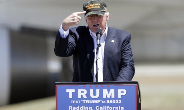 Republican presidential candidate Donald Trump gestures to a his camouflaged “Make America Great” hat as he discuses his support by the National Rifle Association at a campaign rally at the Redding Municipal Airport Friday, June 3, 2016, in Redding, Calif.