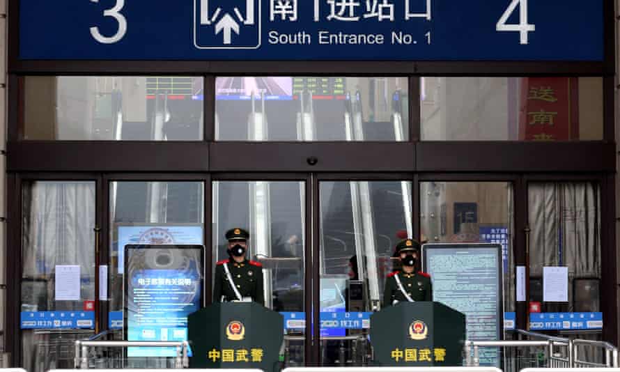 Chinese paramilitary officers wearing masks stand guard at an entrance of the closed Hankou Railway Station after the city was locked down following the outbreak of a new coronavirus in Wuhan.