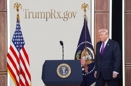 Donald Trump walks toward a lectern under a display that reads âÂÂTrumpRx.govâÂÂ