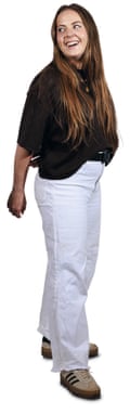 Sarah wearing white trousers, black top - long brown hair and smiling