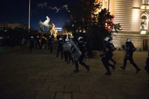 Riot police charge at protesters to clear them from the area in front of government buildings.