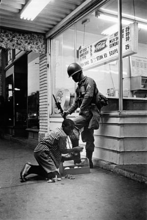 A soldier gets his boots shined during riots in Detroit, July 1967