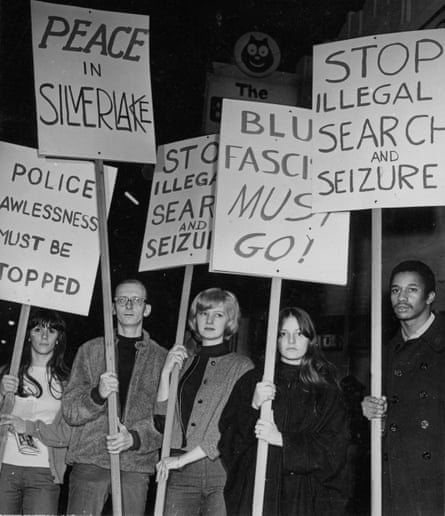 black and white pic of people holding signs that say ‘stop illegal search and seizure’ and ‘peace in silverlake’
