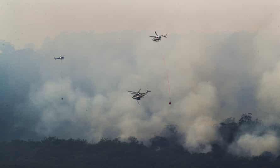 Helicopters drop water on a bushfire near Yiinnar in Gippsland.