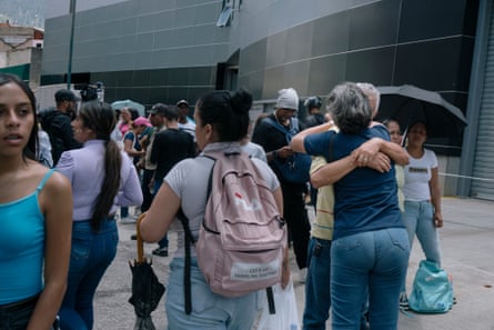 A couple hugs while family members of detainees wait to take food and water to them at the detention centre Zona 7 in Caracas on Thursday.