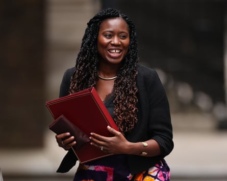 Miatta Fahnbulleh clutches a red folder in a street (blurred behind her)
