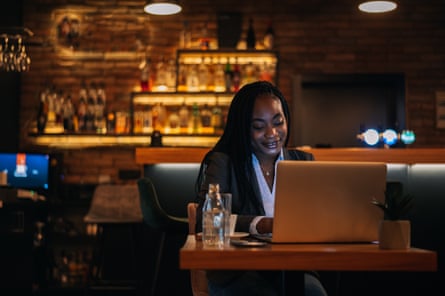 Businesswoman working on her laptop while drinking coffee in a cafe