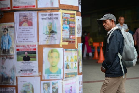 Relatives search through photographs of missing people at the National Trauma Centre in Kathmandu, one week after flash floods struck