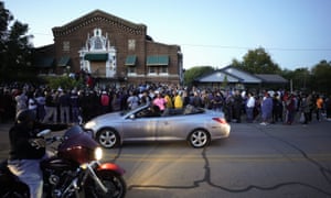 A large crowd of protesters gather outside the house, right, where Atatiana Jefferson was shot Saturday and killed by police, during a community vigil for Jefferson on Sunday, in Fort Worth.