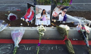 Photos of Jordan Ebner, Anna Bui and Jake Long are seen at a makeshift memorial as people gather in the parking lot of Kamiak High School in Mukilteo, Washington.