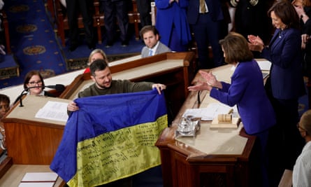Ukraine’s president Volodymyr Zelenskiy presents a Ukrainian flag given to him by defenders of Bakhmut to US house speaker Nancy Pelosi in 2022.