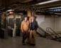 Danny Stewart, 60, and Pete Mercurio, 57, pose for a portrait inside the subway station on 15th Street and 8th Avenue where they found a baby in August of 2000, who they adopted as their son, in New York, NY on Wednesday, March 25, 2026.