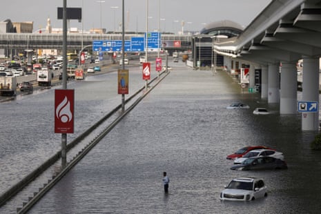 A person stands surrounded by flood water caused by heavy rains, in Dubai, United Arab Emirates, on Wednesday.