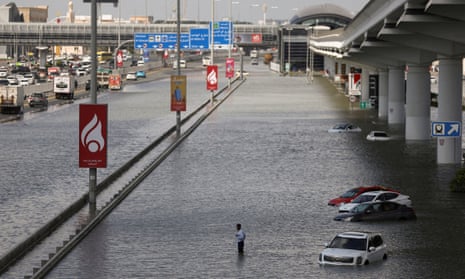 A person stands surrounded by flood water caused by heavy rains, in Dubai, United Arab Emirates, on Wednesday.