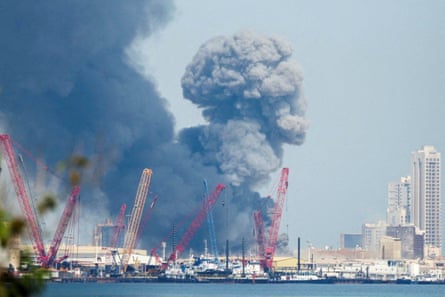 Smoke rises over buildings by the sea
