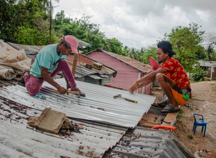 Two man fix the roof of a house before the arrival of Hurricane Melissa in Barahona, the Dominican Republic.
