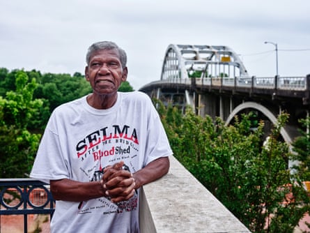 A man posing with a bridge in the background