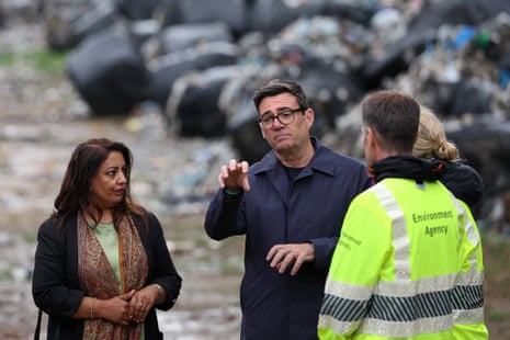 O deputado trabalhista de Bradford West Naz Shar (L) e funcionários da agência ambiental mostram ao primeiro-ministro britânico Andy Burnham (C), um depósito de lixo ilegal perto do campo de futebol de Bradford City, em Bradford, norte da Inglaterra, em 20 de agosto de 2026.