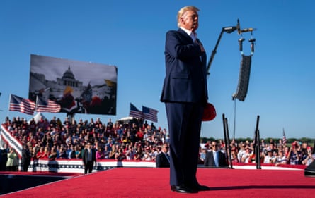 Footage of the January 6 Capitol insurrection plays as Donald Trump holds a campaign rally in Waco, Texas, in 2021.