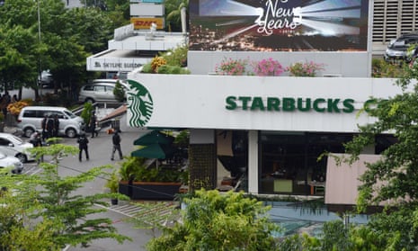Police secure the area outside a Starbucks coffee shop after a series of explosions in central Jakarta