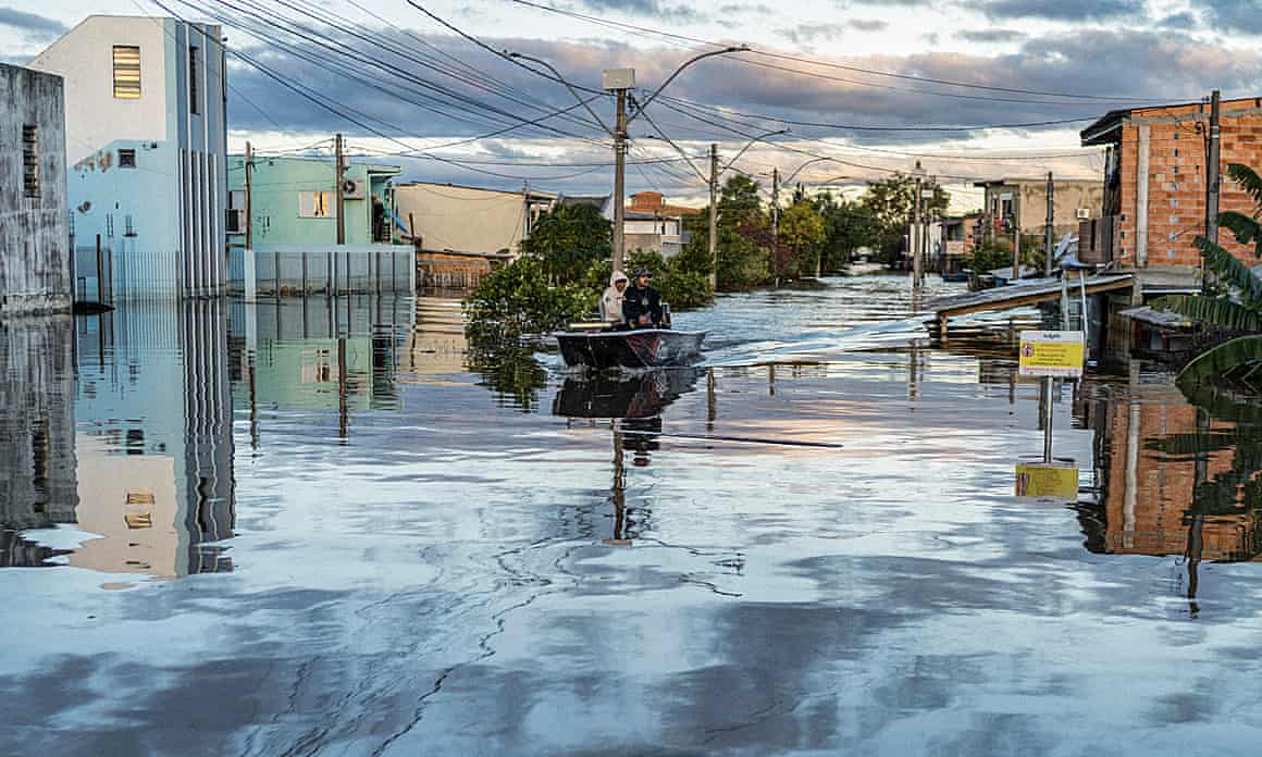 A boat with people onboard on a flooded street