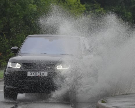 A Range Rover driving in a puddle