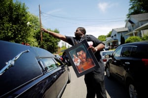 A man throws a rose over the hearse carrying the remains of Muhammad Ali