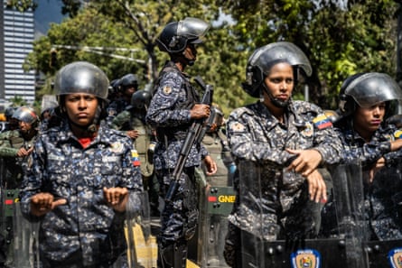 Riot police stand ready at the entrance of Caracas’ main university in January 2019