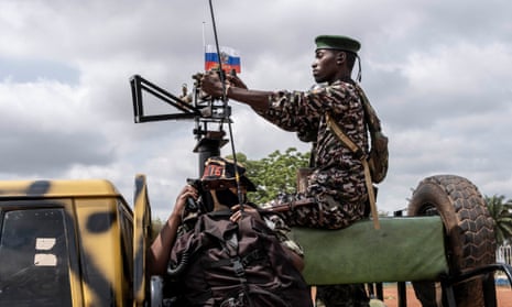 A soldier from the government Central African territorial infantry battalion passes a Russian flag  in Bangui in December 2022.  