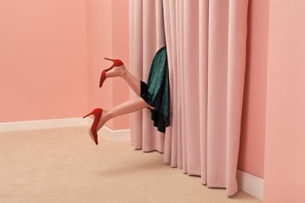 The legs of a woman tipping over through window curtains.