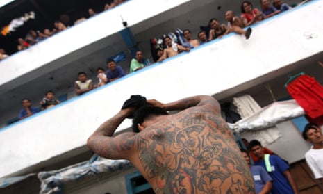 A Filipino inmate shows his tattoo outside a crowded cell in New Bilibid Prison