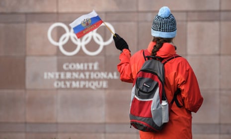 A supporter waves a Russian flag in front of the logo of the International Olympic Committee at their headquarters near Lausanne.