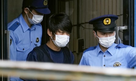 Tetsuya Yamagami is escorted by police officers as he is taken to prosecutors in Nara.