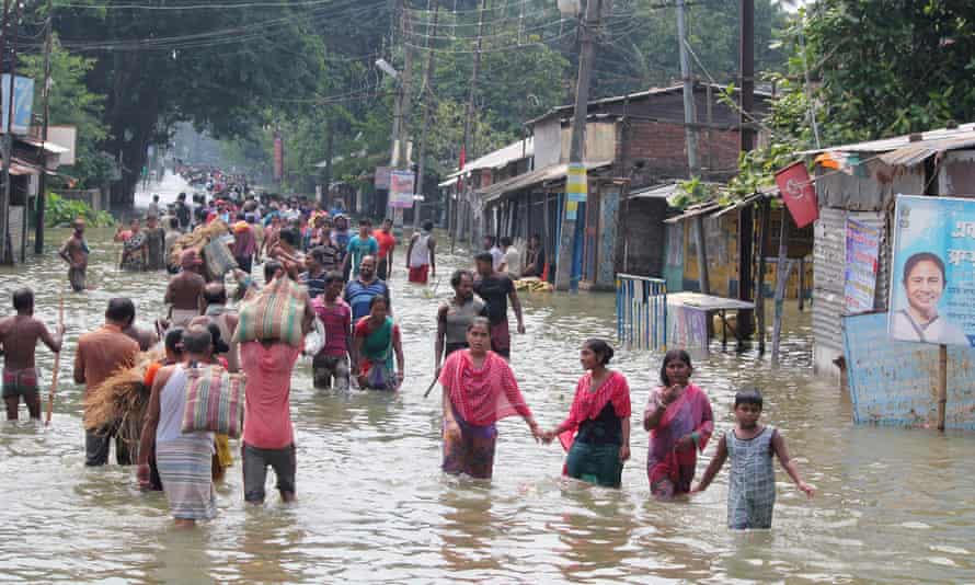 Indian residents wade through flood waters in Balurghat in West Bengal after torrential rain across India, Nepal and Bangladesh that killed hundreds of people