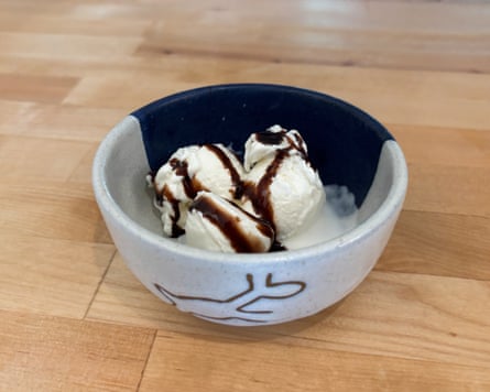 A bowl of vanilla ice cream with chocolate syrup